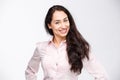 Portrait of a young woman with a charming toothy smile, black hair and brown eyes on a white background in a pink shirt. Positive Royalty Free Stock Photo