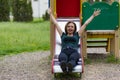 Portrait of a young woman on a childrens slide with copy space. Freedom and happiness concept