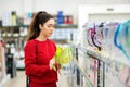 Portrait of young woman chooses a light green carafe with a water filter in a home appliance store. The concept of consumerism