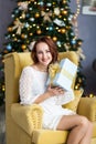 Portrait of young woman with christmas present boxes in front of christmas tree Royalty Free Stock Photo