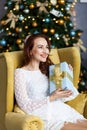 Portrait of young woman with christmas present boxes in front of christmas tree Royalty Free Stock Photo