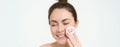 Portrait of young woman cleansing her face, takes off her makeup, washing her face, using skincare routine with cotton Royalty Free Stock Photo