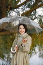 Portrait of a young woman in a coat under a transparent umbrella Royalty Free Stock Photo