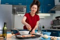 Portrait of a young woman cooking a pizza. Kitchen on the background. Homemade cooking concept Royalty Free Stock Photo