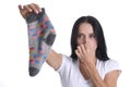 Portrait of young woman covering nose and holding sock in hand closeup Royalty Free Stock Photo