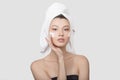 Portrait of a young woman with cream on her face. hand touch to the cheek. A towel on her head Royalty Free Stock Photo