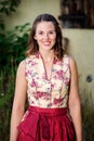 Young woman in dirndl standing in front of farmhouse Royalty Free Stock Photo