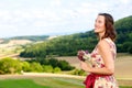 Young woman in dirndl standing in meadow with flowers and enjoying the sun Royalty Free Stock Photo