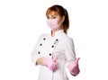 Portrait of young woman doctor or nurse in white special uniform, gloves and protective mask showing thumb up sign