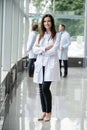 Portrait of young woman doctor with white coat standing in hospital. Royalty Free Stock Photo