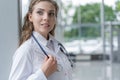 Portrait of young woman doctor with white coat standing in hospital. Royalty Free Stock Photo