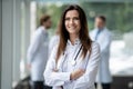 Portrait of young woman doctor with white coat standing in hospital. Royalty Free Stock Photo