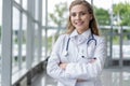 Portrait of young woman doctor with white coat standing in hospital. Royalty Free Stock Photo