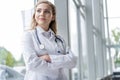 Portrait of young woman doctor with white coat standing in hospital. Royalty Free Stock Photo