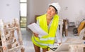 Portrait of a young woman with documents, checking the house repair plan on a laptop Royalty Free Stock Photo