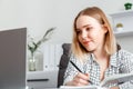 Portrait Young woman doing paper work in office using laptop During working day In office interior. Student girl Royalty Free Stock Photo