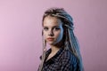 Portrait of a young woman with dreadlocks and piercings.