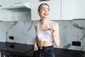 Portrait of a young woman drinking water in the kitchen at home Royalty Free Stock Photo