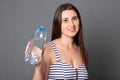 Happy woman holds a bottle of water. Portrait of a young woman drinks water from a bottle Royalty Free Stock Photo