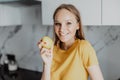Portrait of young woman eating apple in kitchen Royalty Free Stock Photo