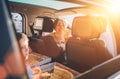 Portrait of young woman eating just cooked Italian pizza while she traveling with family in modern car. Happy family moments and