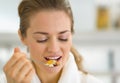 Portrait of young woman eating muesli in kitchen Royalty Free Stock Photo