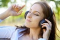 Portrait of young woman enjoying listening to music on headphones outdoors in nature Royalty Free Stock Photo