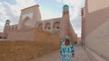 Woman in ethnic dress near Madrassah in Ichan Kala of Khiva