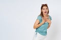 Portrait of young woman expressing astonishment and shock, mouth wide opened, holding hands on her chest isolated over white Royalty Free Stock Photo