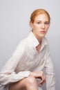 Portrait of a young woman with exquisite makeup in a linen shirt with long sleeves. Artistic studio photography