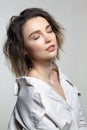 Portrait of young woman with eyes closed. Female posing in milky white corduroy shirt