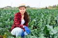 Portrait of young woman farmer in straw hat posing in farm field