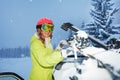 Portrait of young woman fastening skis on car roof