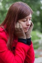 Portrait of a young woman feeling depressed sitting on a forest