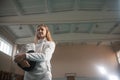 A portrait of a young woman fencer holding her helmet