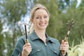 Portrait young woman gardener with gardening tools outdoors