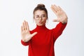 Portrait of young woman in glasses pucker lips and make hand camera frames gesture, capturing moment, standing over