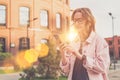 Portrait of young woman in glasses standing outdoors and using smartphone. Girl is walking along the city street Royalty Free Stock Photo
