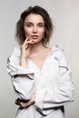 Portrait of young woman on gray background. Female posing in milky white corduroy shirt