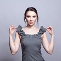 Portrait of young woman in gray dress on grÃÂµy background