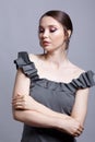 Portrait of young woman in gray dress on grÃÂµy background