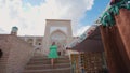 Woman in ethnic dress near Madrassah in Ichan Kala of Khiva