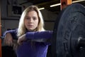 Portrait Of Young Woman In Gym Lifting Weights On Barbell Royalty Free Stock Photo