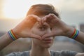 . Portrait of young woman hands with gay pride LGBT rainbow flag wristband making heart sign Royalty Free Stock Photo