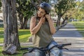 Portrait of a young woman on her bike putting on a black helmet Royalty Free Stock Photo