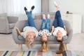 Portrait of young woman, her mature mother and daughter lying upside down on sofa Royalty Free Stock Photo