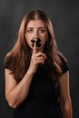 Portrait of a young woman with her mouth sealed with black tape, restriction of freedom of speech, censorship and a ban Royalty Free Stock Photo