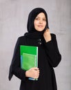 Portrait of young woman in hijab holding stack of notebooks Royalty Free Stock Photo