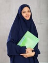 Portrait of young woman in hijab holding stack of notebooks Royalty Free Stock Photo