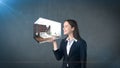 Portrait of young woman holding 3d interior on the open hand palm, over isolated studio background. Business concept.